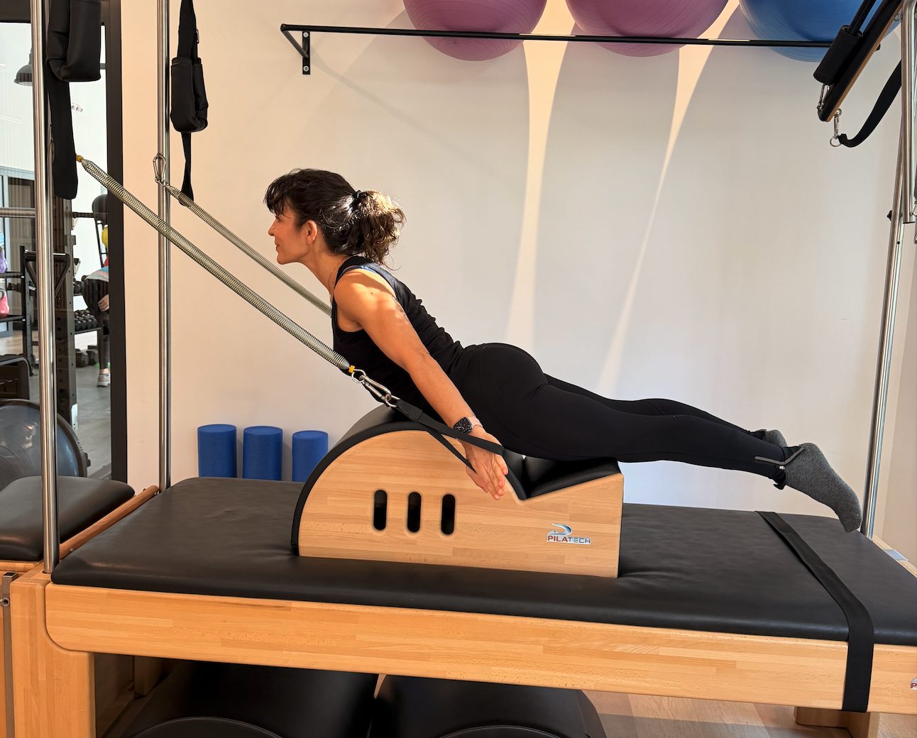 Ejercicio de control motor sobre Cadillac de Pilates en Clínica Motriz, Tres Cantos